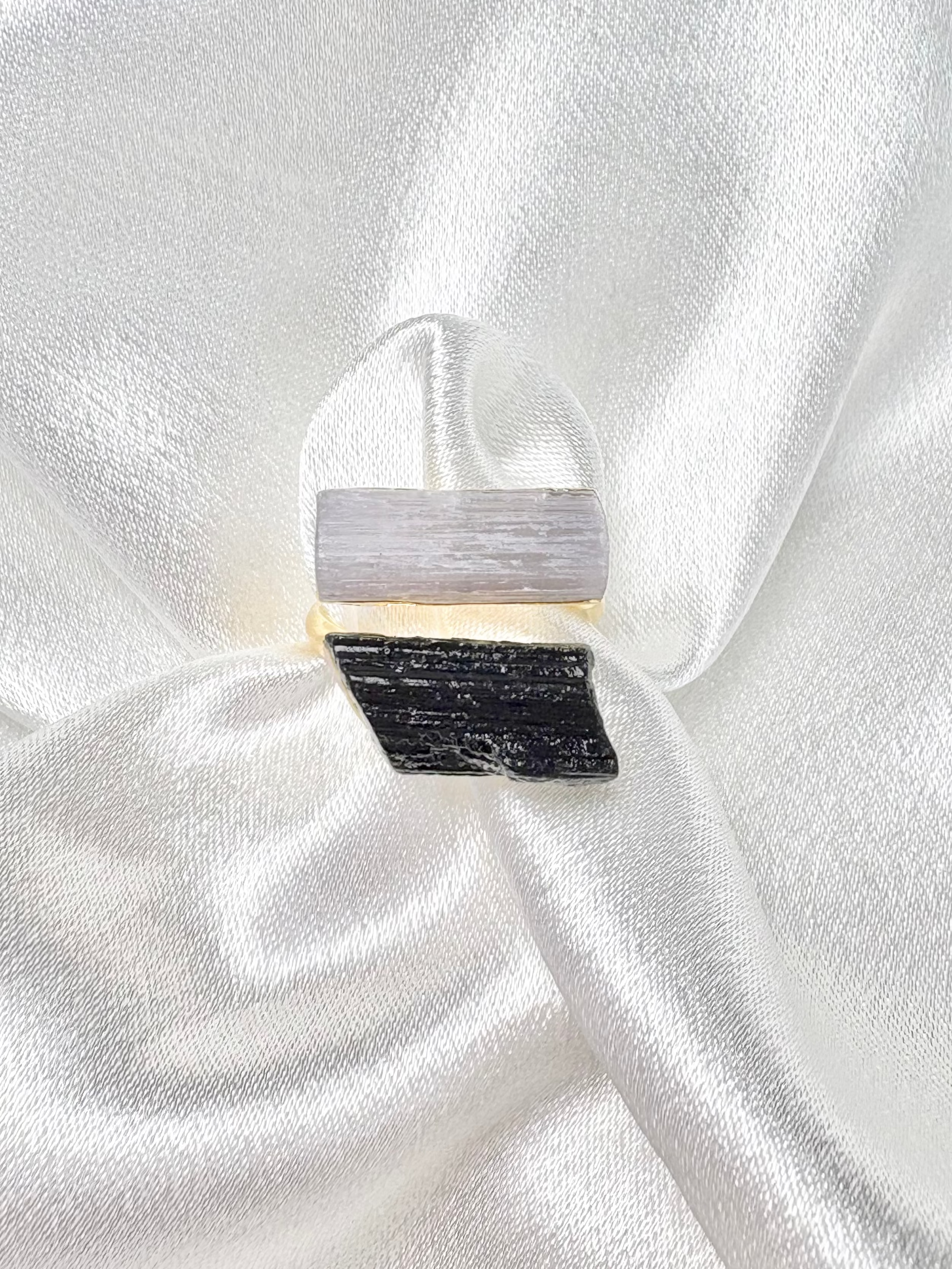 Close-up of clear quartz and black tourmaline crystals set on gold adjustable band AquaBrasil jewelry