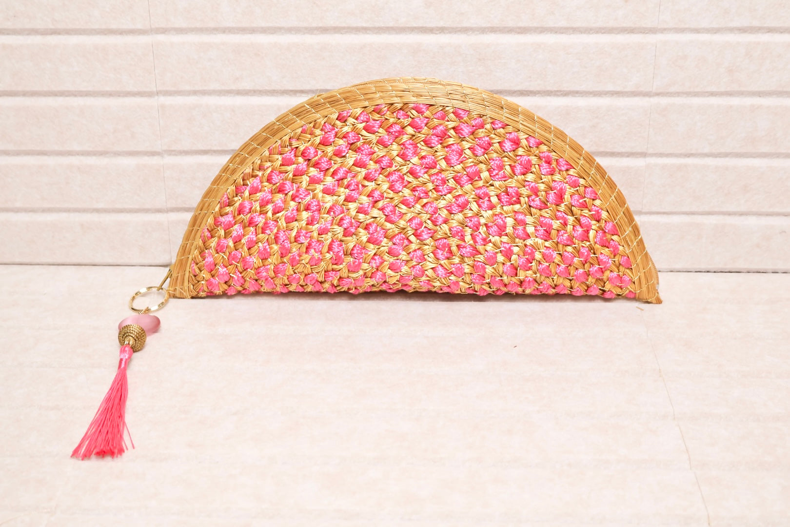 golden grass clutch with pink crochet intertwine and tassel charm handcrafted in Brazil AquaBrasil