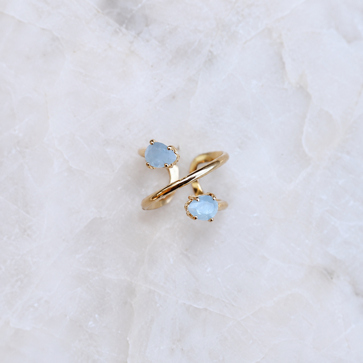 Double Aquamarine spiral ring with two natural faceted teardrop gemstones and 18K gold-plated adjustable band