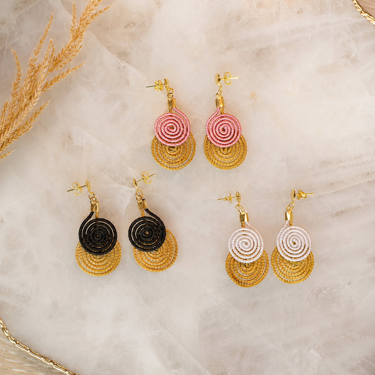 Handwoven Golden Grass spiral drop earrings with 18K gold dipped details available in blush pink, ivory, and black.