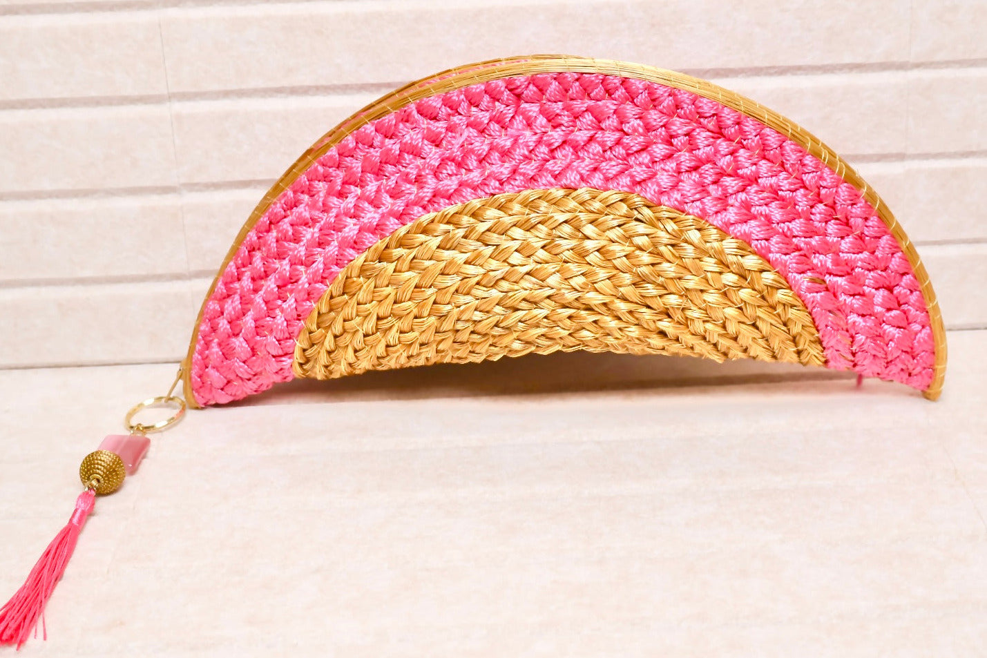 golden grass half moon clutch with pink crochet design and tassel charm handcrafted in Brazil AquaBrasil