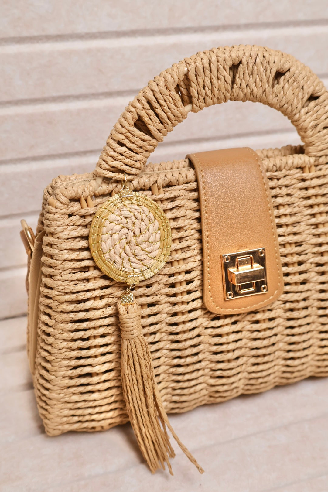 close up of rattan bag with vegan leather details and golden grass charm accent AquaBrasil