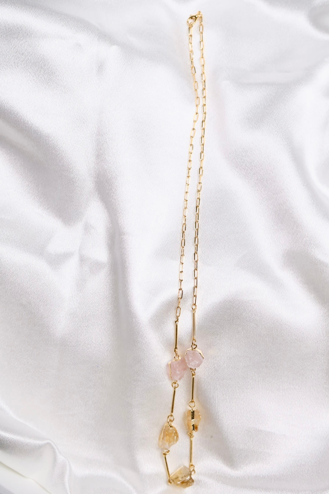 Close up of stones raw citrine and rose quartz necklace AquaBrasil