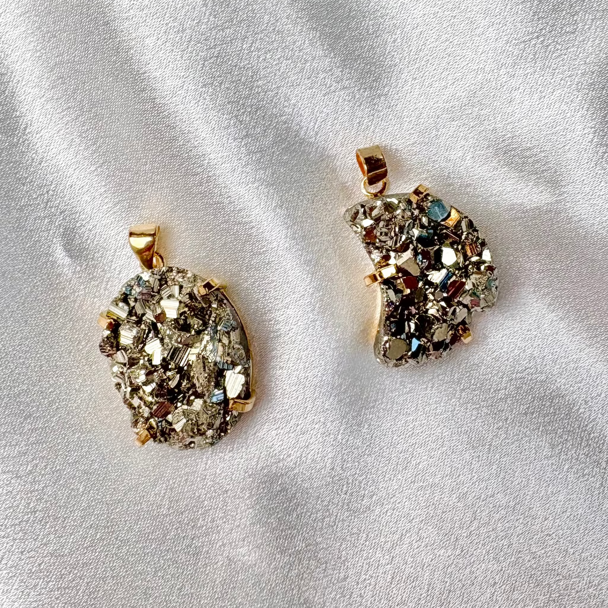 two large pyrite pendants handcrafted in Brazil one round and one moon shaped with 18k gold plated details AquaBrasil jewelry