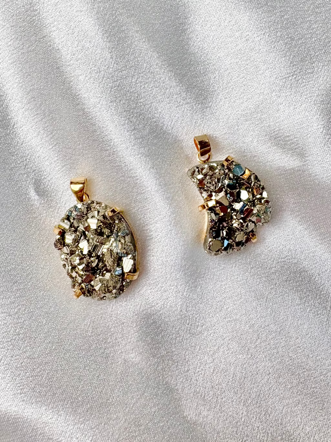 two large pyrite pendants handcrafted in Brazil one round and one moon shaped with 18k gold plated details AquaBrasil jewelry
