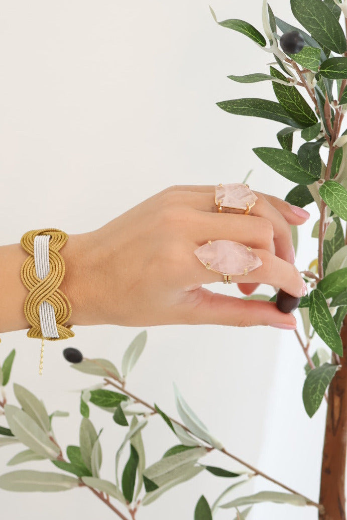 Model wearing our marquise shaped rose quartz ring and a free form style ring with golden grass cuff