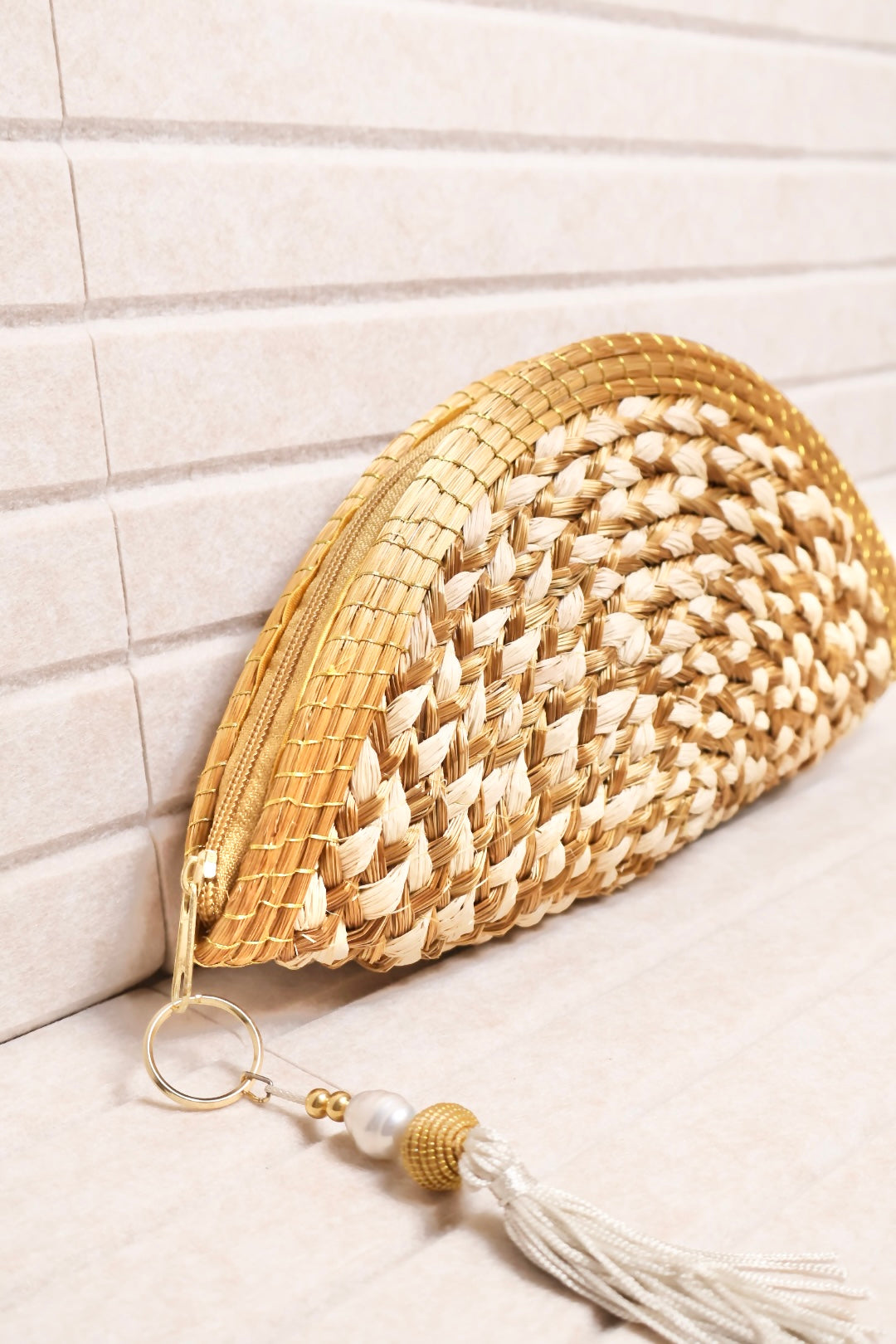 handwoven golden grass and buriti clutch with silk lining and tassel charm AquaBrasil