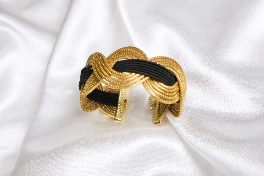 close up of golden grass statement cuff with intertwined black thread AquaBrasil