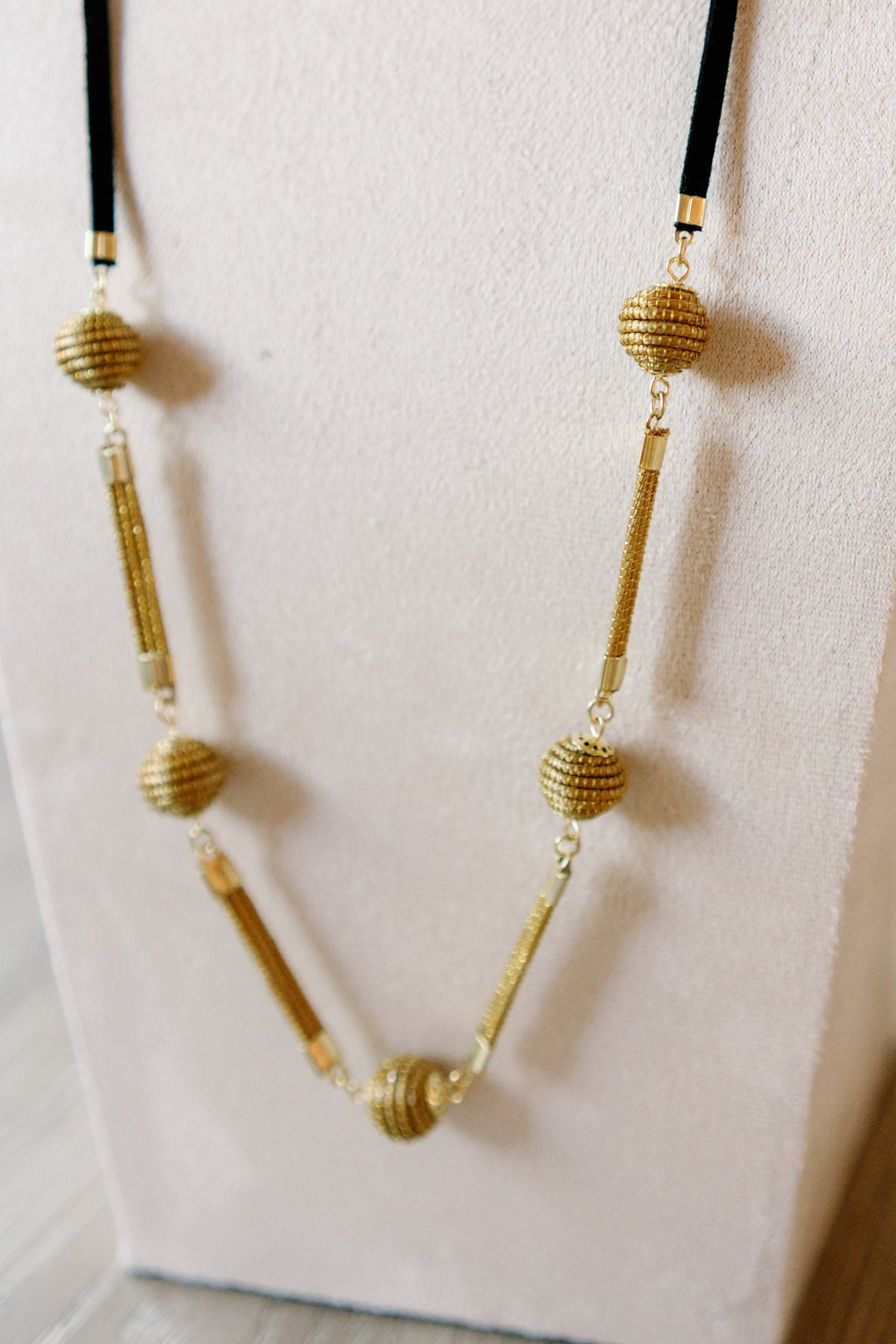 sol necklace handcrafted with golden grass beads and black suede cord long statement design by AquaBrasil