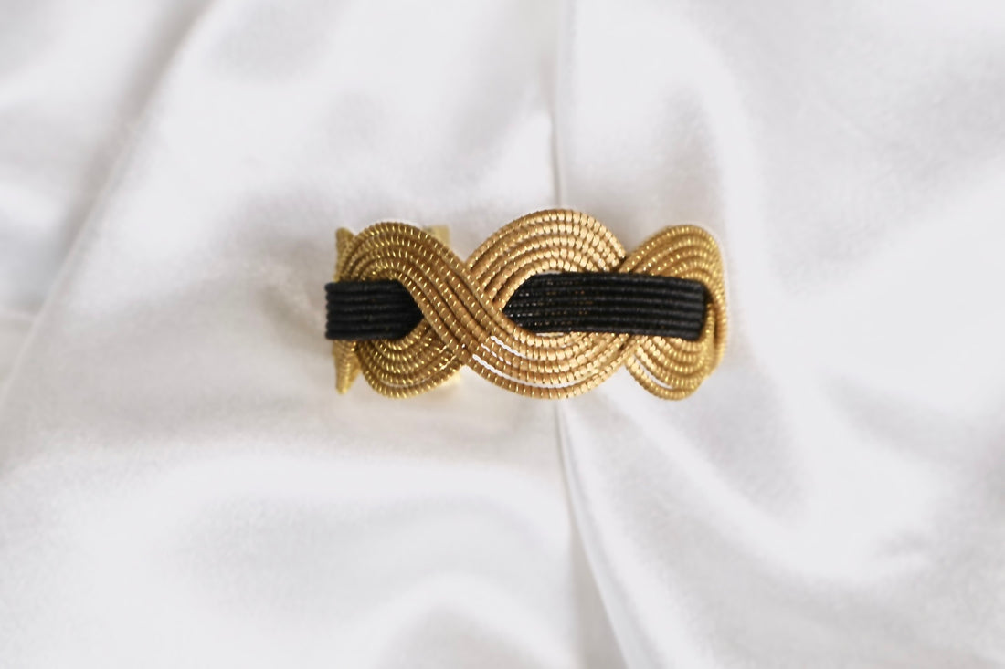close up of golden grass statement cuff with intertwined black thread AquaBrasil